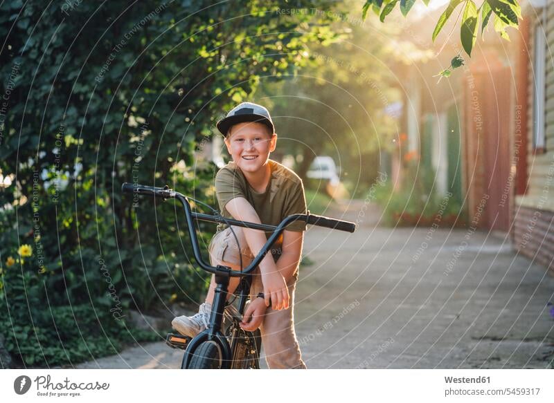 Portrait of smiling boy with bmx bike on road portrait portraits bicycle bikes bicycles smile BMX bmx bicycle Bycicle Moto Cross boys males child children kid