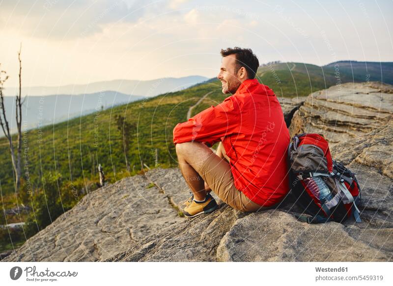 Man sitting on rock enjoying the view during hiking trip indulgence enjoyment savoring indulging View Vista Look-Out outlook rocks man males mountain mountains