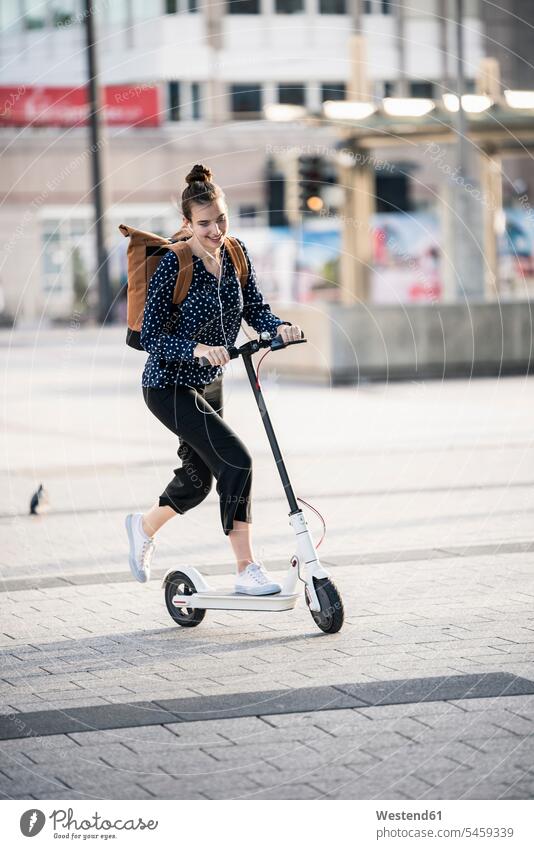 Young woman riding electric scooter in the city human human being human beings humans person persons caucasian appearance caucasian ethnicity european 1