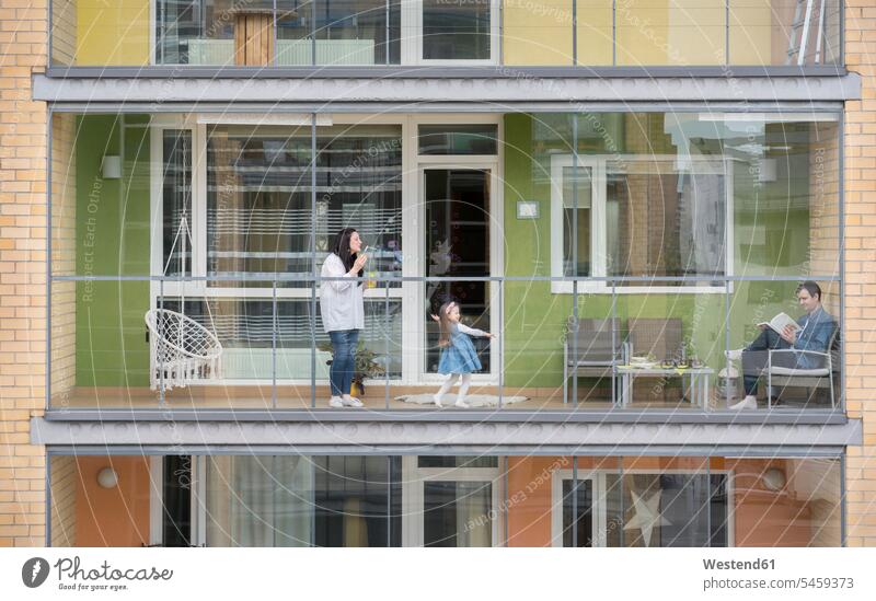 Family spending time together on balcony windows soap bubbles play free time leisure time Lifestyle contemporary location shot location shots outdoor