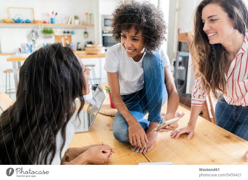 Three happy women talking at table at home woman females Table Tables smiling smile female friends speaking Adults grown-ups grownups adult people persons