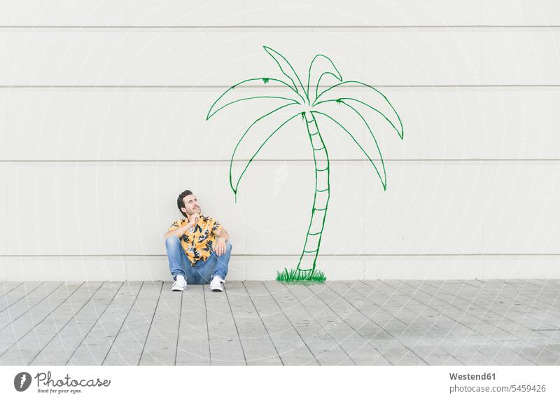 Digital composite of young man sitting at a palm at a wall human human being human beings humans person persons caucasian appearance caucasian ethnicity