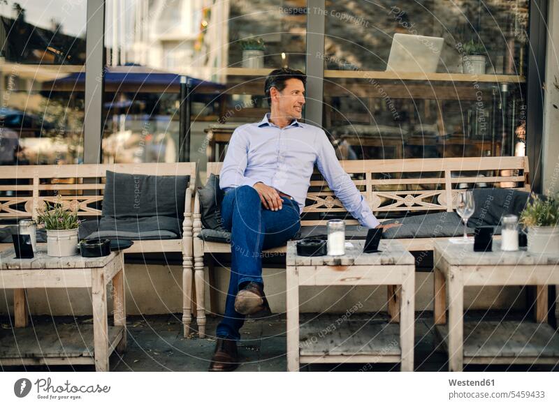 Businessman sitting in coffee shop, smiling Success successful cafe Seated Business man Businessmen Business men business people businesspeople business world