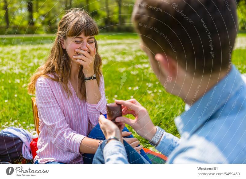 Young man proposing to his girlfriend in a park Tuscany Quality Time Life Events Lifetime Event sitting on ground Sitting On The Floor Sitting On Floor