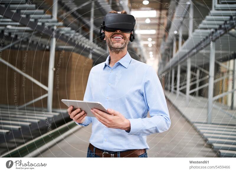 Businessman with tablet wearing VR glasses in factory Occupation Work job jobs profession professional occupation business life business world business person