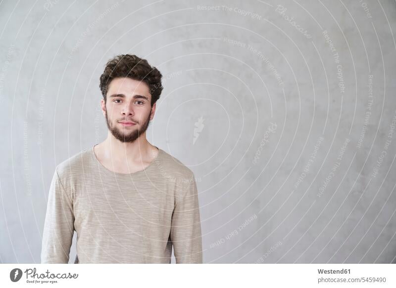 Portrait of confident young man in front of grey wall portrait portraits confidence caucasian caucasian ethnicity caucasian appearance european one person 1