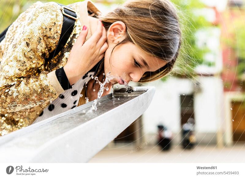 Girl drinking water of a fountain girl females girls fountains child children kid kids people persons human being humans human beings sequin sequins golden
