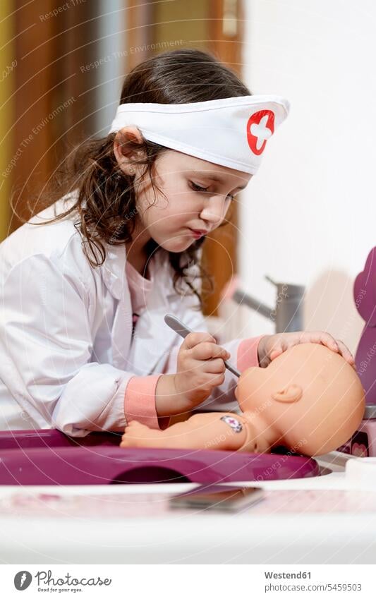 Girl in doctor's costume caring of her doll basin basins toys dolls play at home healthy protect protecting safe Safety secure domestic room domestic rooms