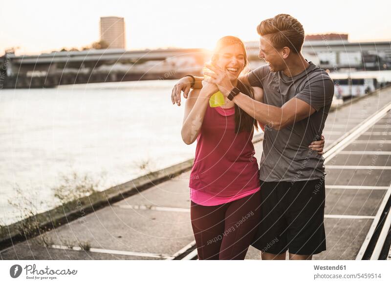 Cheerful friends talking while walking at harbor color image colour image outdoors location shots outdoor shot outdoor shots Sportswear Sports Wear
