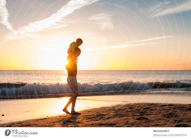 Mother walking with little daughter on the beach at sunset baby infants nurselings babies going beaches mother mommy mothers ma mummy mama daughters sunsets