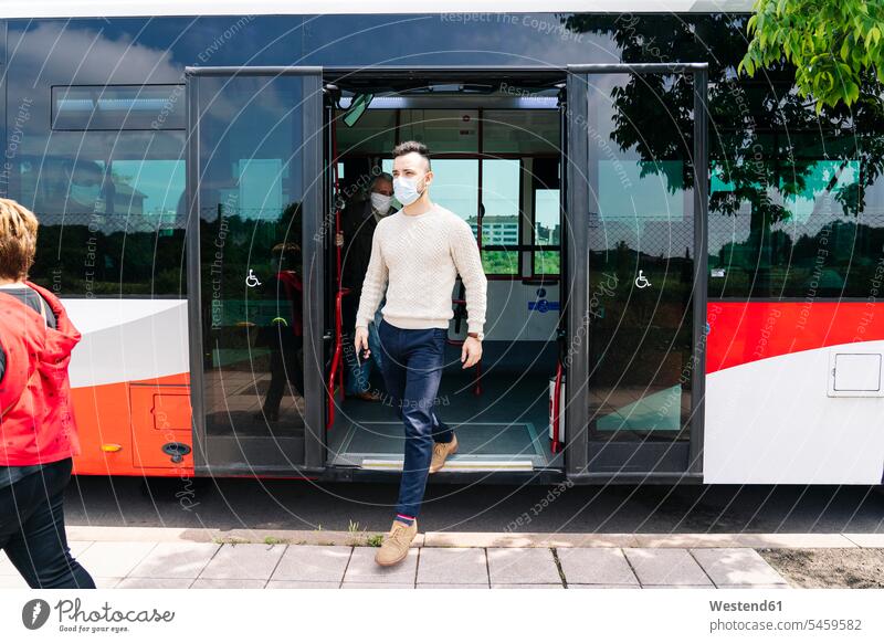 Young man wearing protective mask getting off public bus, Spain human human being human beings humans person persons caucasian appearance caucasian ethnicity