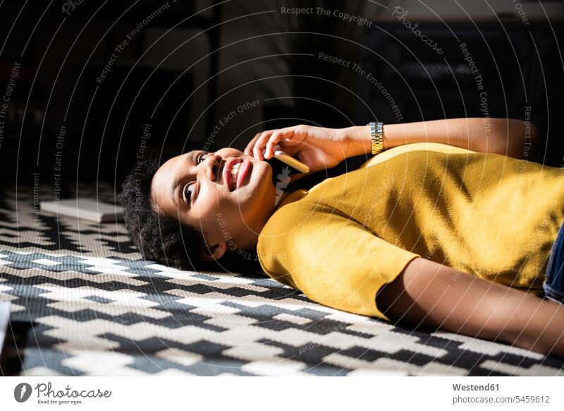 Young woman lying on the floor at home talking on the phone human human being human beings humans person persons celibate celibates singles solitary people