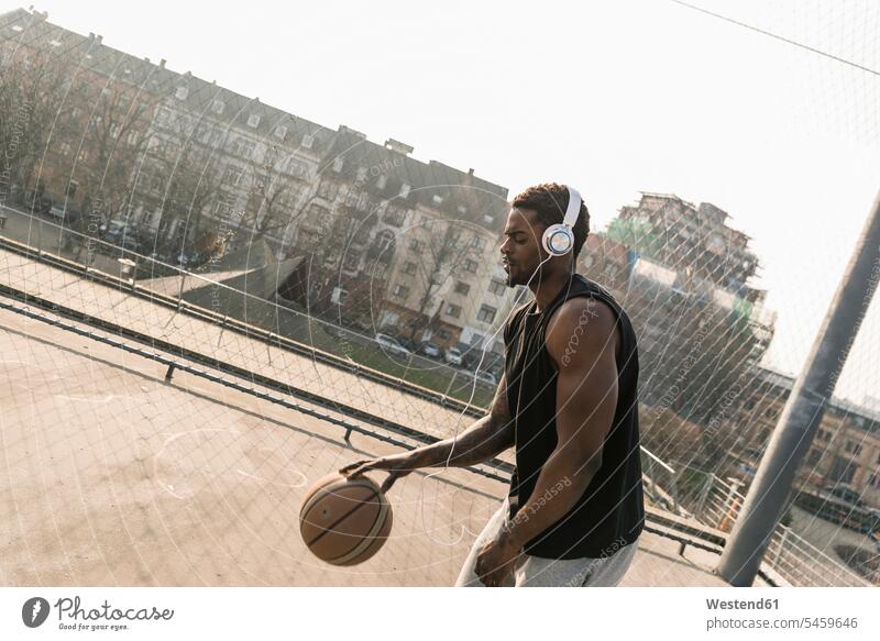 Basketball player with headphones in action on court Action sports field sports fields basketball basketballs man men males basketball player basketball players