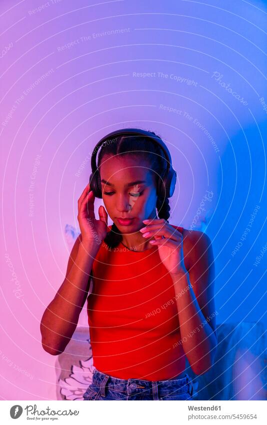 Thoughtful woman listening music through headphone sitting at home color image colour image indoors indoor shot indoor shots interior interior view Interiors