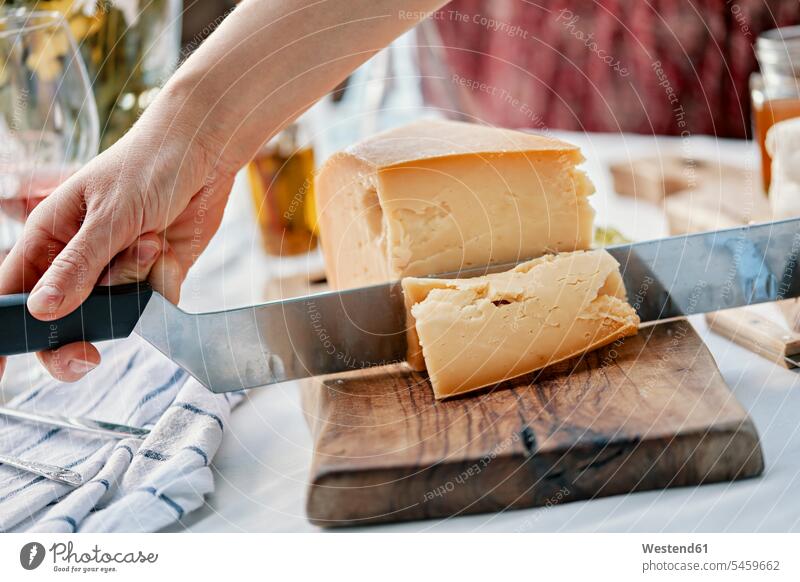 Hands cutting cheese on wood human human being human beings humans person persons caucasian appearance caucasian ethnicity european 1 one person only