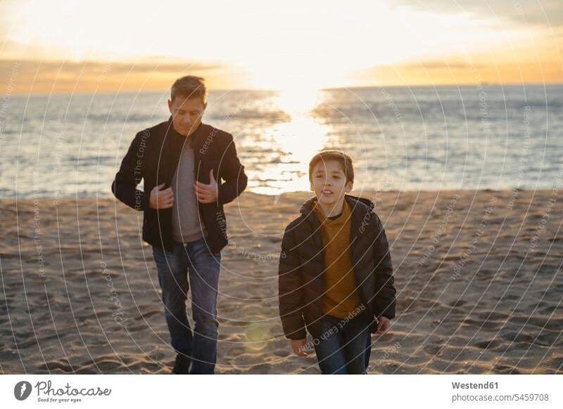 Father and son walking on the beach at sunset beaches sunsets sundown father pa fathers daddy dads papa going sons manchild manchildren atmosphere atmospheric