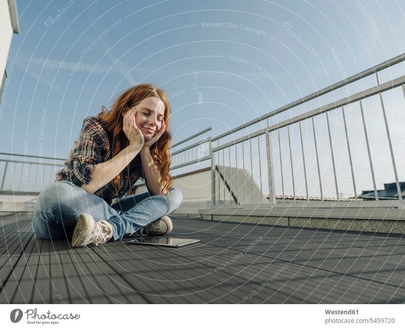 Redheaded woman with tablet relaxing on rooftop terrace human human being human beings humans person persons caucasian appearance caucasian ethnicity european 1