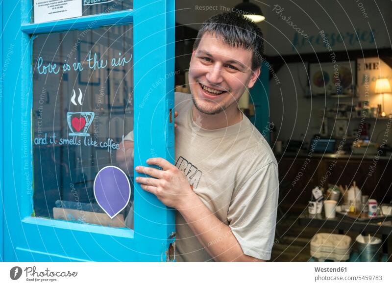 Portrait of a smiling coffee roaster on the door of a coffee roastery smile coffee roasters shop man men males portrait portraits retail trade trading Adults