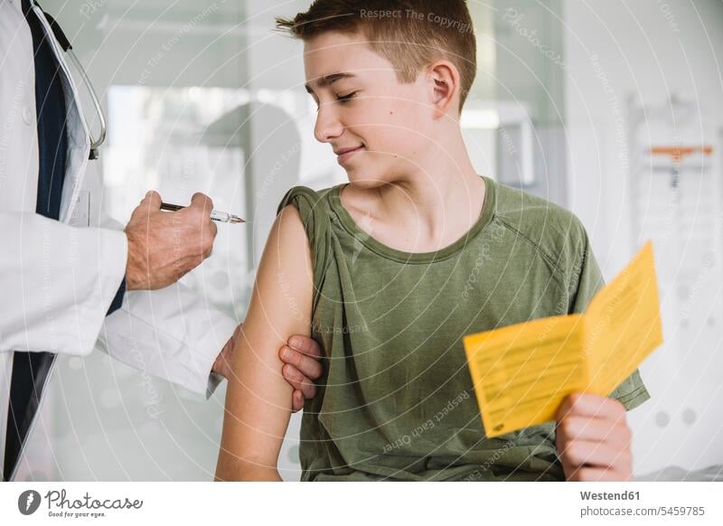 Doctor injecting a vaccine into teenager’s arm health healthcare Healthcare And Medicines medical medicine disease diseases ill illnesses sick Sickness patients