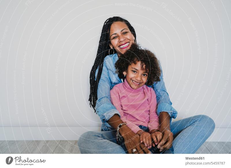 Portrait of happy mother and her little daughter sitting together on the floor human human being human beings humans person persons 2 2 people 2 persons two