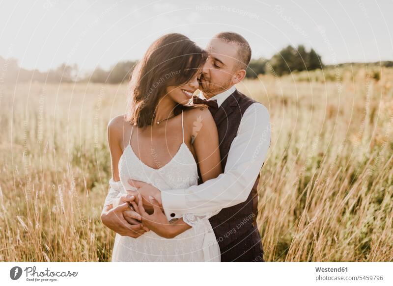 Couple embracing each other at field on sunny day color image colour image outdoors location shots outdoor shot outdoor shots daylight shot daylight shots