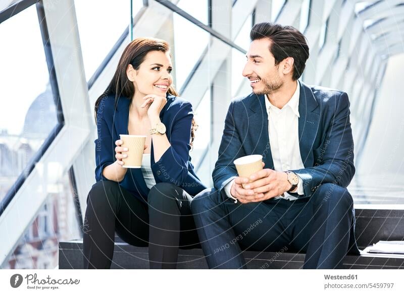 Smiling businesswoman and businessman having a coffee break in modern office contemporary offices office room office rooms businesswomen business woman