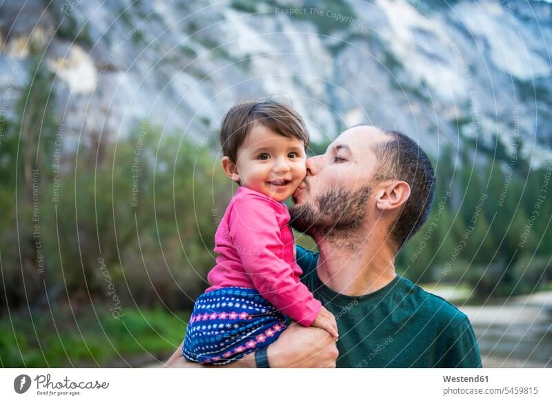 Portrait of happy baby girl kissed by her father, Yosemite National Park, California, USA human human being human beings humans person persons