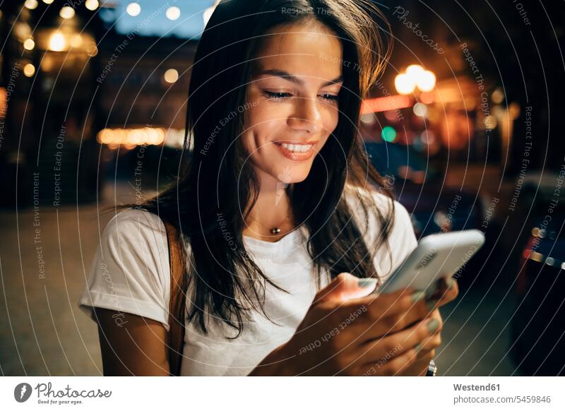 Young woman using smartphone in the city at night telecommunication phones telephone telephones cell phone cell phones Cellphone mobile mobile phones mobiles