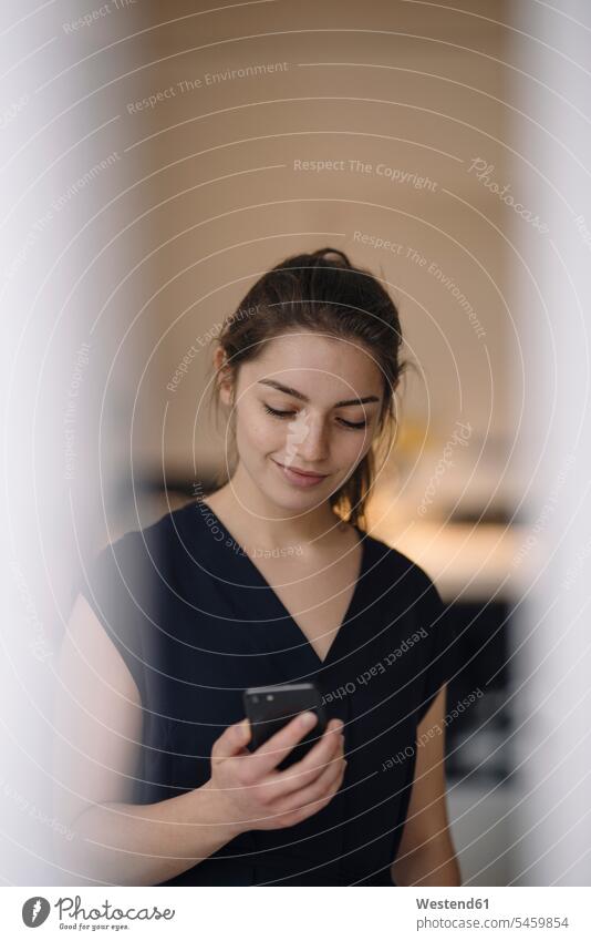 Portrait of smiling young woman looking at mobile phone human human being human beings humans person persons caucasian appearance caucasian ethnicity european 1