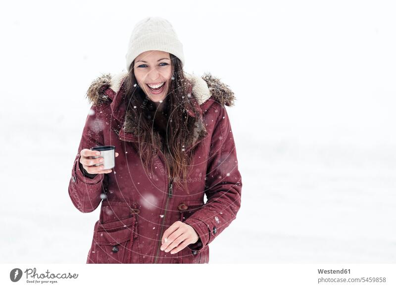 Portrait of laughing young woman with hot beverage in snow relax relaxing drink seasons hibernal Ardor Ardour enthusiasm enthusiastic excited delight enjoyment