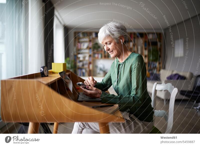 Active senior listening music while sitting on chair at home color image colour image indoors indoor shot indoor shots interior interior view Interiors day