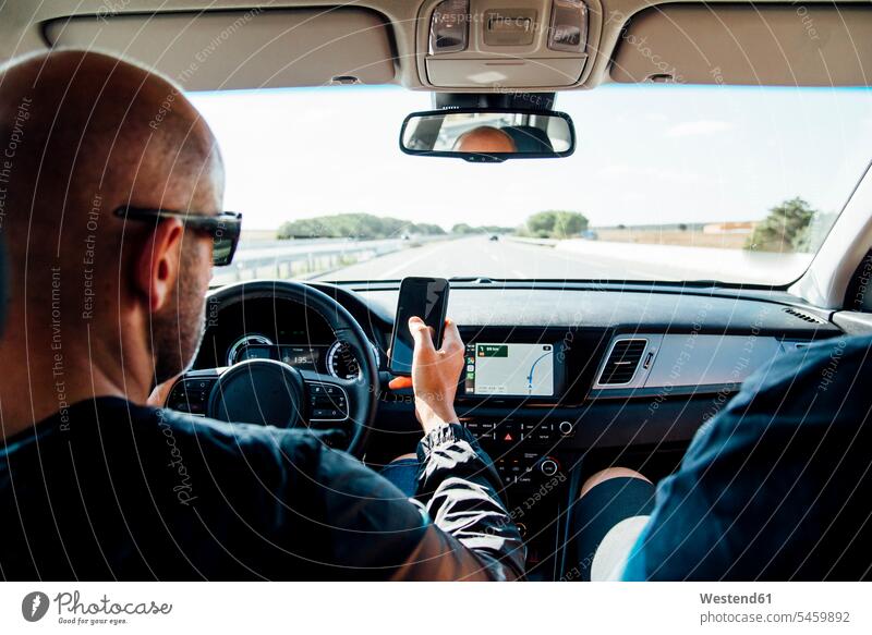 Man sitting in a car using his smartphone human human being human beings humans person persons caucasian appearance caucasian ethnicity european 1