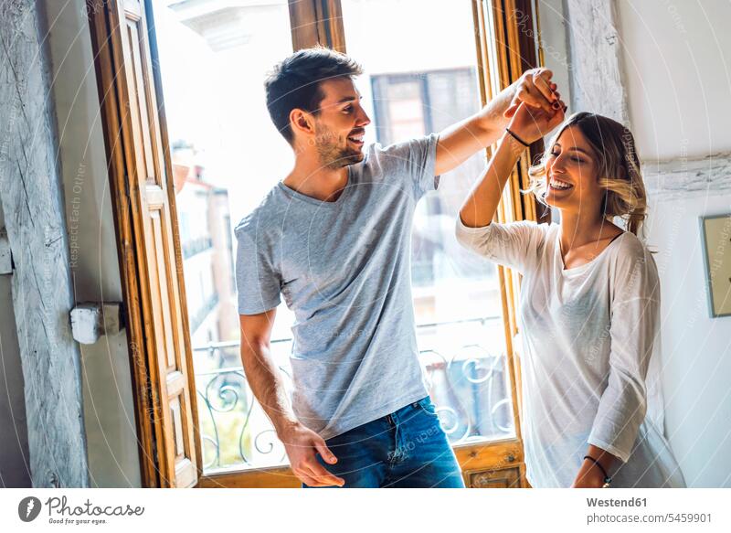 Happy young couple dancing at the window at home windows smile delight enjoyment Pleasant pleasure happy passionate emotional Emotions Feeling Feelings