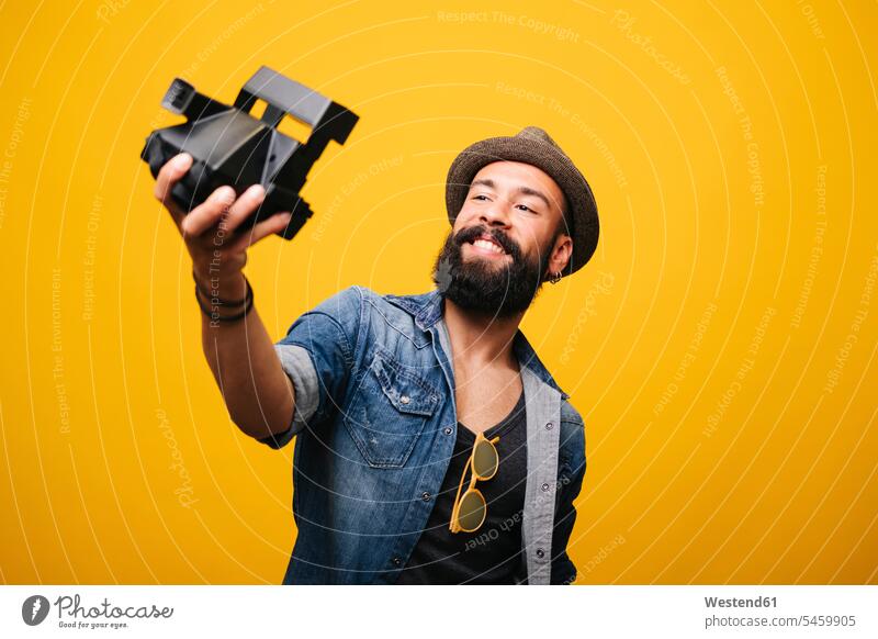 Bearded young man in studio taking selfie with instant camera human human being human beings humans person persons African black black ethnicity coloured