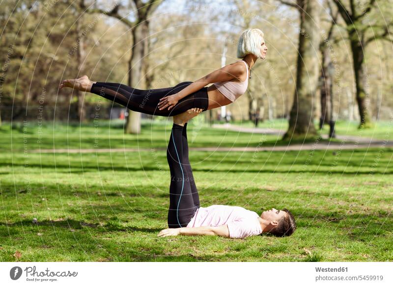 Young couple doing yoga acrobatics in an urban park effortless effortlessness easy training Sport Training recreational exercises leisure time sports