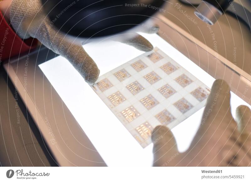 Close-up of woman working on the quality control in the manufacturing of ceramic circuit boards for the electronics industry ceramics electrical industry