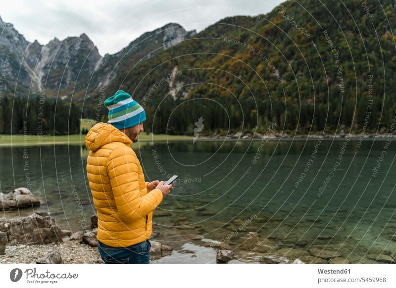 Hiker using smartphone at Laghi di Fusine, Friuli Venezia Giulia, Italy human human being human beings humans person persons caucasian appearance