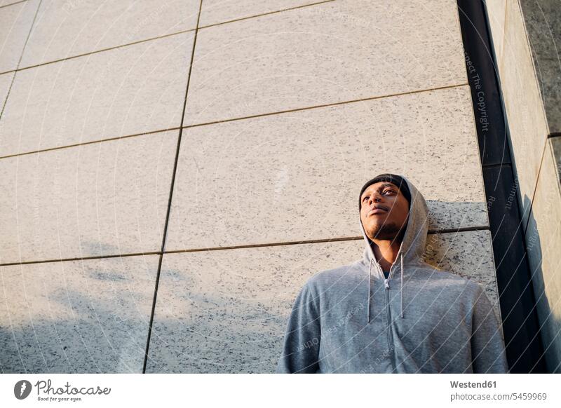 Portrait of young man leaning against a wall human human being human beings humans person persons African black black ethnicity coloured 1 one person only