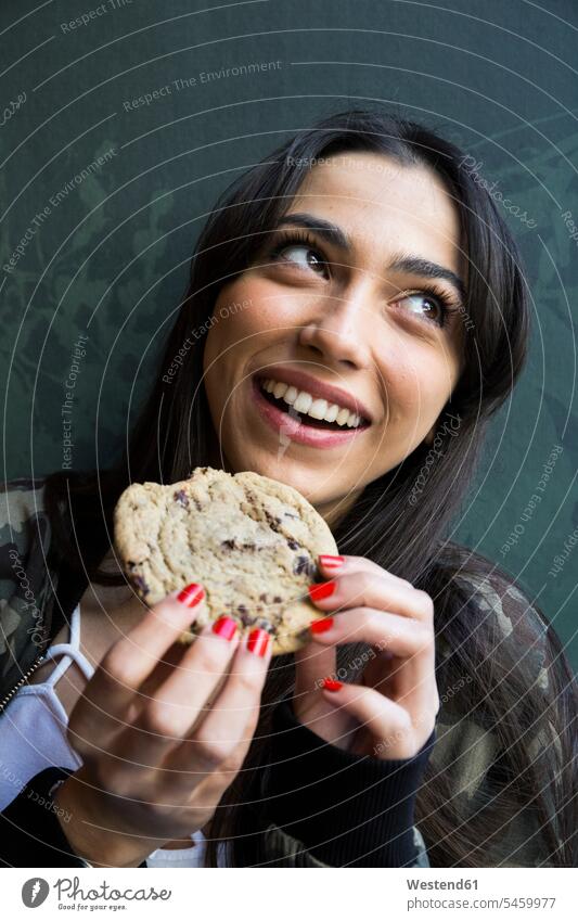 Smiling woman looking sideways and eating cookie human human being human beings humans person persons caucasian appearance caucasian ethnicity european 1