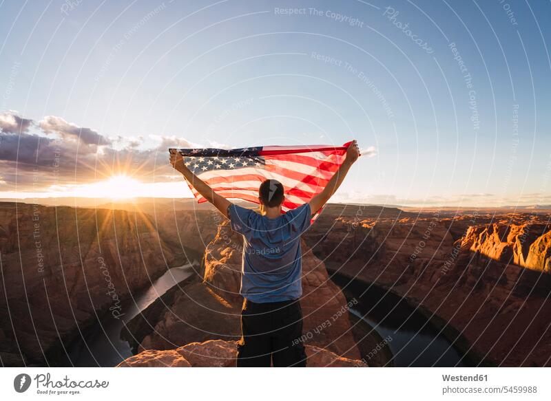 USA, Arizona, Colorado River, Horseshoe Bend, young man on viewpoint with American flag men males Traveller Travellers Travelers Identity awe Fascinating