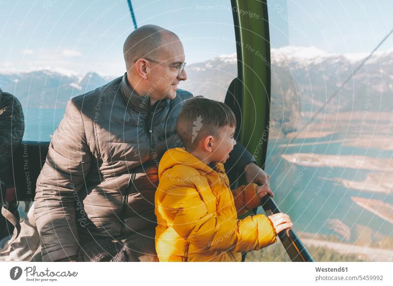 Father and son in the gondola of a cable car, Squamish, Canada boy boys males gondola lift gondola cableway Looking At View Looking at a view amazement amazed