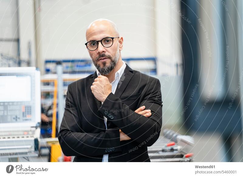 Portrait of serious businessman in a factory Businessman Business man Businessmen Business men portrait portraits earnest Seriousness austere factories