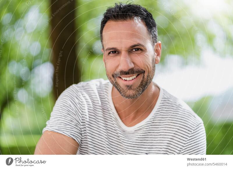 Portrait of smiling man in a park caucasian caucasian ethnicity caucasian appearance european Head and shoulders upper body Head And Shoulder Head Shot nature
