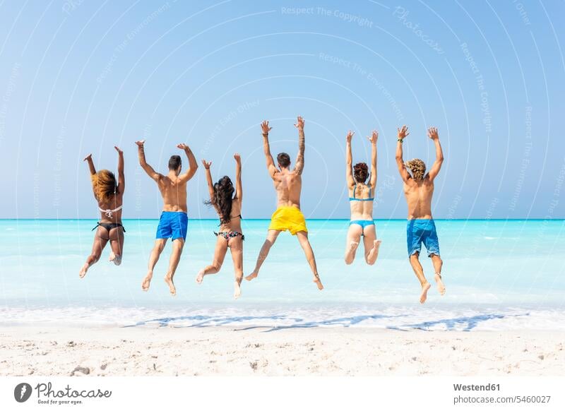 Group of friends at the beach, jumping for joy Fun having fun funny sea ocean beaches Leaping active water waters body of water friendship jumps Activity