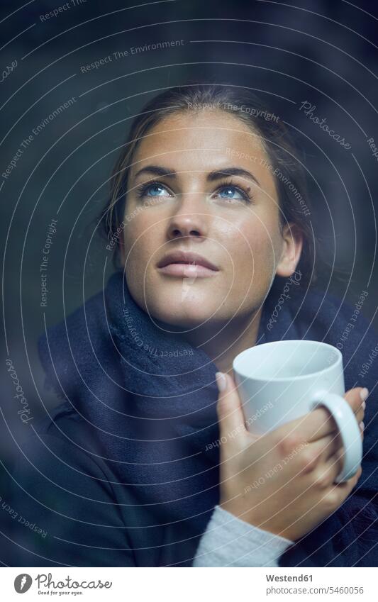 Portrait of young woman with coffee mug looking out of window watching windows portrait portraits females women Coffee Mug Coffee Mugs view seeing viewing