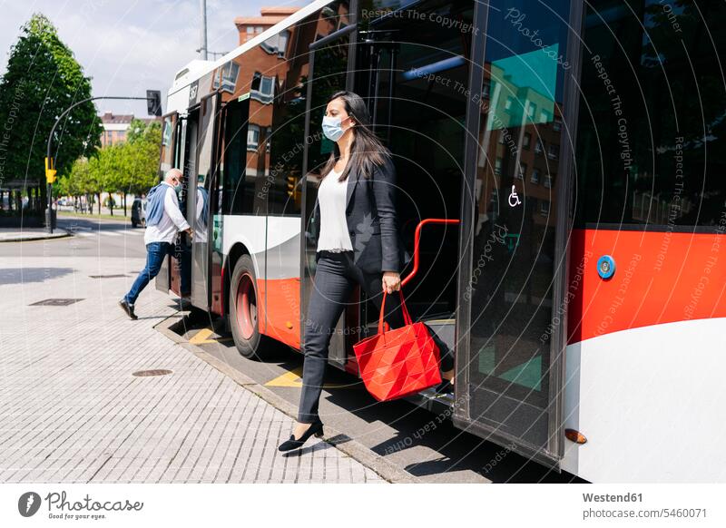 Woman wearing protective mask getting off public bus, Spain human human being human beings humans person persons caucasian appearance caucasian ethnicity