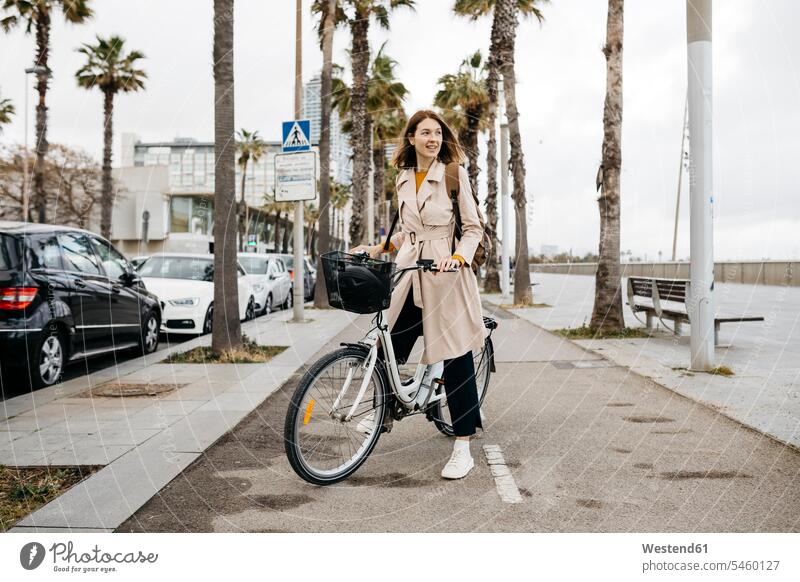 Smiling woman with e-bike on a promenade promenades E-Bike Electric bicycle Electric Bike bikes bicycles smiling smile females women transportation Adults