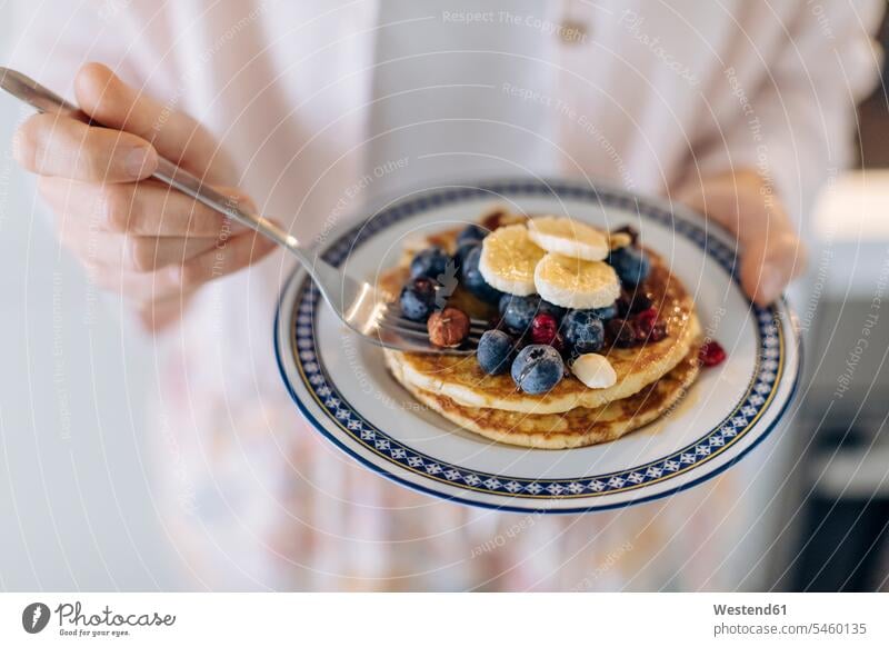 Close-up of woman holding a plate with pancakes and fruit human human being human beings humans person persons caucasian appearance caucasian ethnicity european