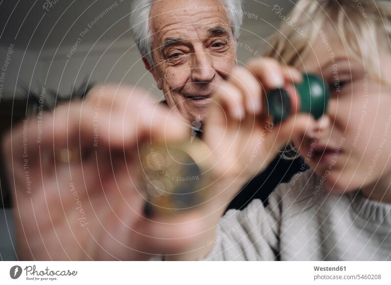 Watchmaker and his grandson examining watch together human human being human beings humans person persons caucasian appearance caucasian ethnicity european 2