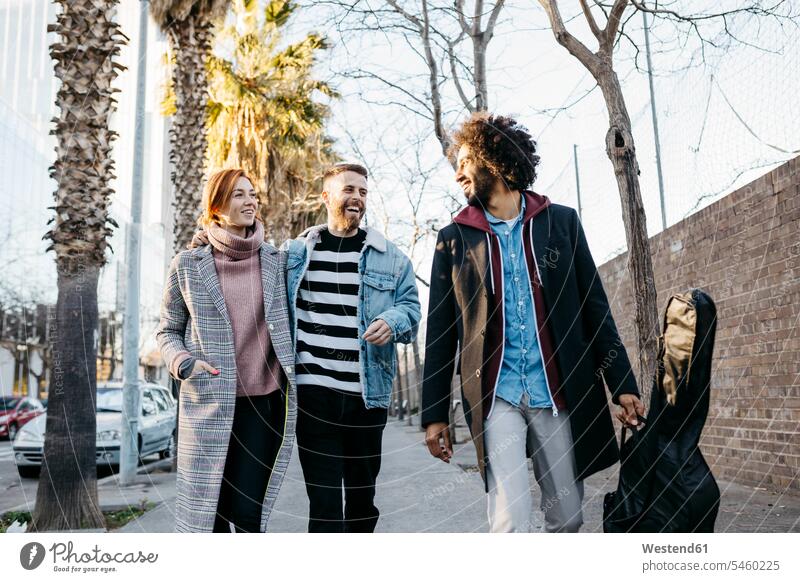 Three happy friends walking in the city happiness going friendship brick wall brick walls fashionable togetherness style stylish Barcelona lifestyle life styles